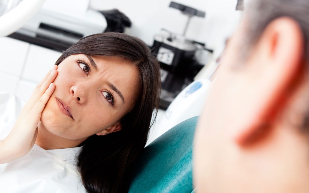 Dentist examining a patient's tooth to check for signs of a root canal infection in McKinney, TX