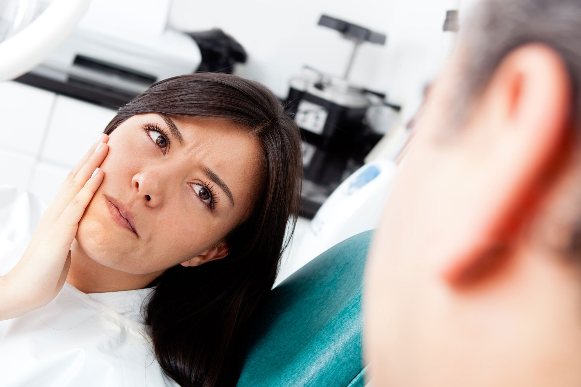 Dentist examining a patient's tooth to check for signs of a root canal infection in McKinney, TX